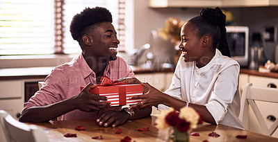 Buy stock photo Cropped shot of an affectionate young man giving his wife a wrapped gift on Valentine's day at home