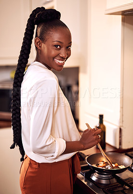 Buy stock photo Cropped portrait of an attractive young woman cooking in her kitchen at home
