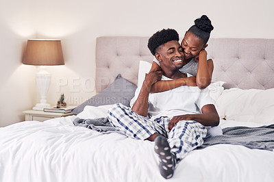 Buy stock photo Shot of an affectionate couple relaxing on their bed wearing pajamas