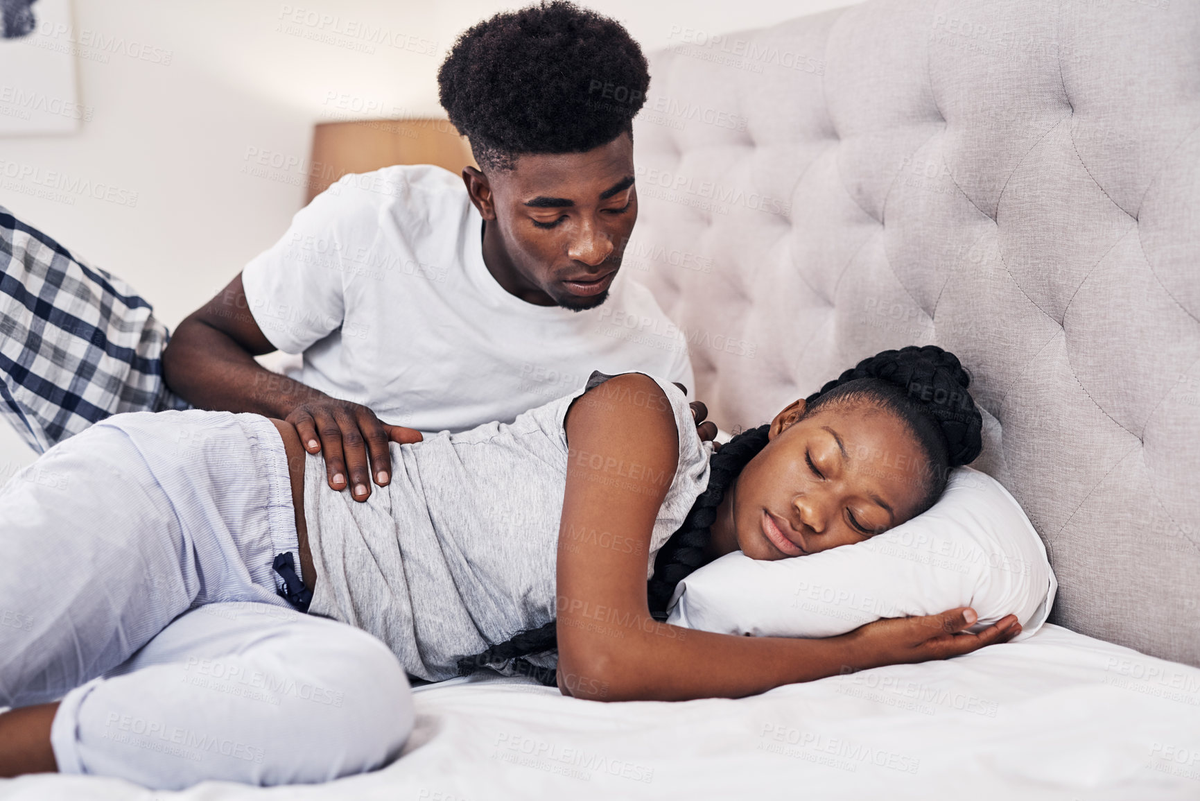 Buy stock photo Shot of a young man checking on his girlfriend who's asleep