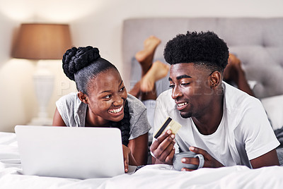 Buy stock photo Shot of a young couple using a credit card while surfing the net