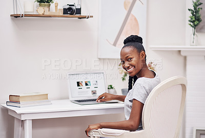 Buy stock photo Shot of a young woman using her laptop while sitting at a desk at home