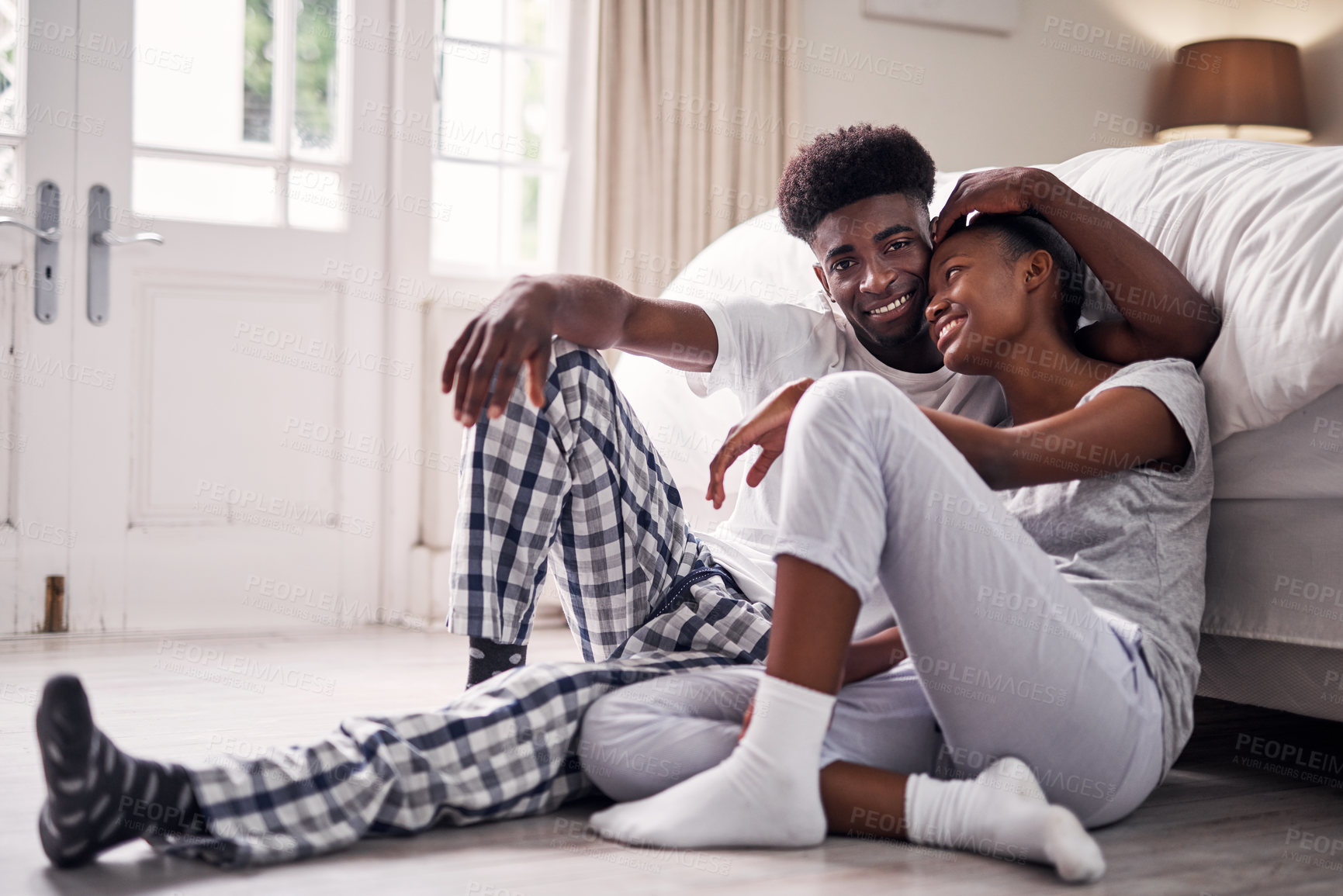 Buy stock photo Black couple, love and bedroom floor with hug, care and support together in the morning in home. Bed, ground and romance of happy young people with a smile, bonding and commitment on the weekend