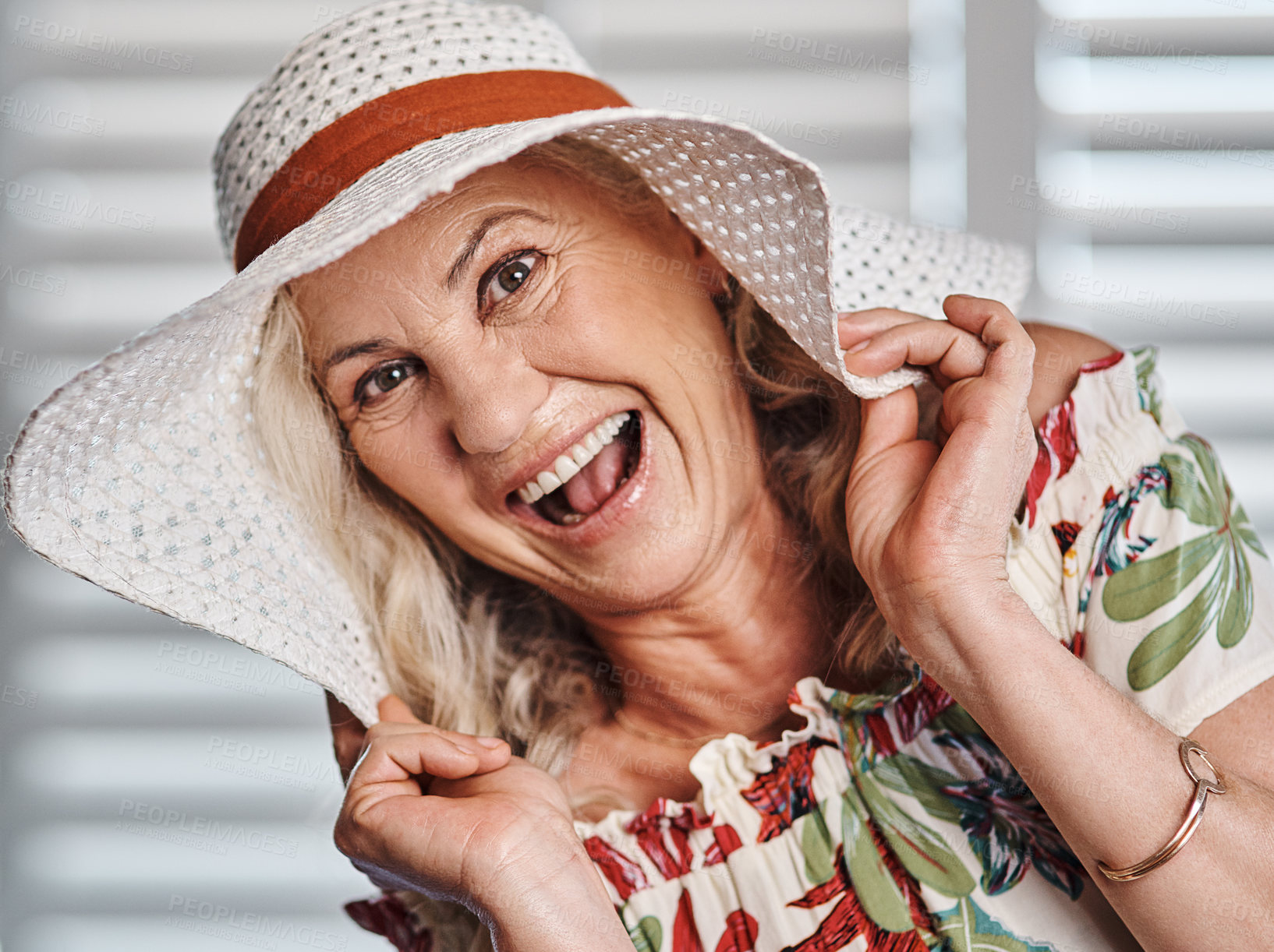 Buy stock photo Senior woman, portrait and laughing for holiday fashion, home and hat to relax on vacation at hotel. Female person, confident style and retirement for happy getaway, weekend trip and travel for peace