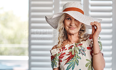 Buy stock photo Cropped portrait of an attractive senior woman wearing a summer hat while standing indoors during the day