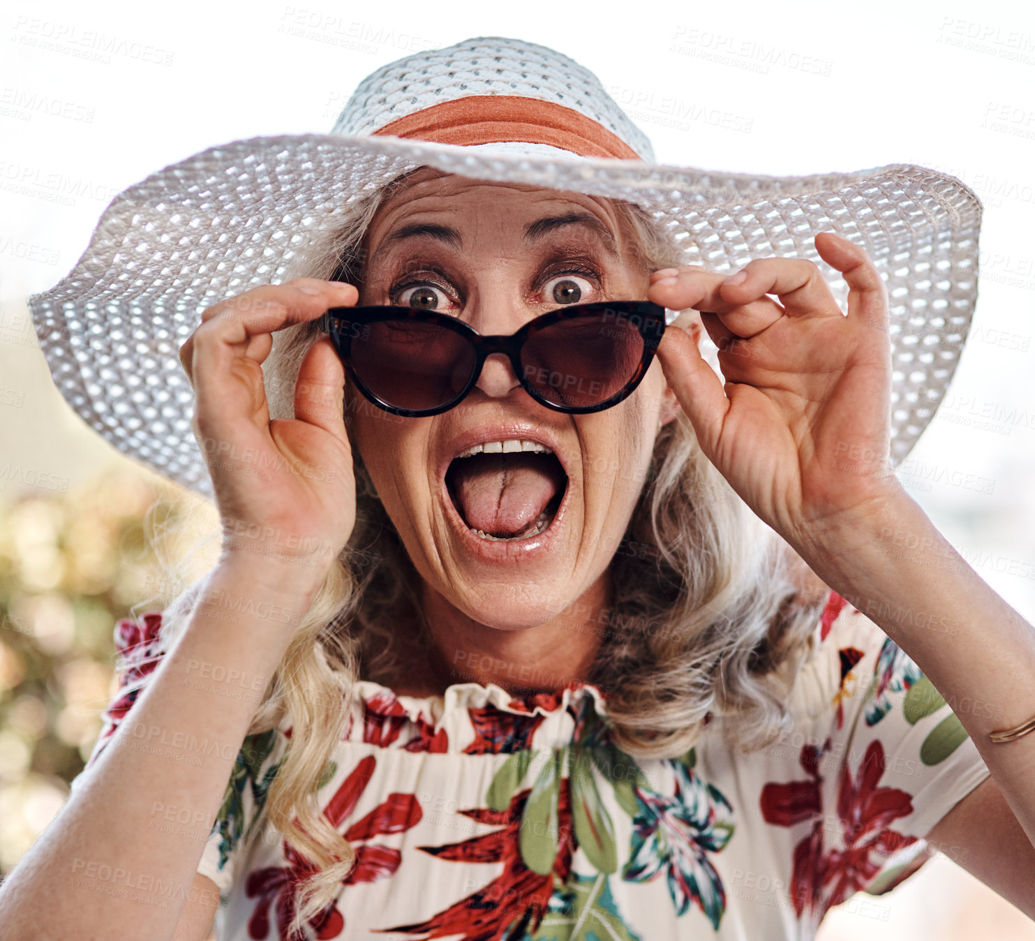 Buy stock photo Cropped portrait of an attractive senior woman looking surprised while wearing sunglasses outdoors