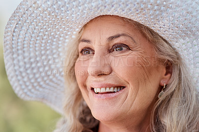 Buy stock photo Cropped shot of an attractive senior woman smiling while standing outdoors on a summer's day