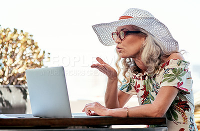 Buy stock photo Laptop, video call and senior woman with kiss for communication on vacation at outdoor table. Computer, person and blow love in air to contact in virtual meeting and online chat on summer holiday