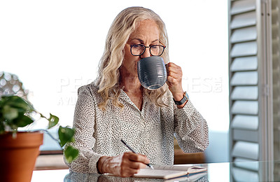 Buy stock photo Cropped shot of an attractive senior businesswoman drinking coffee while working from home