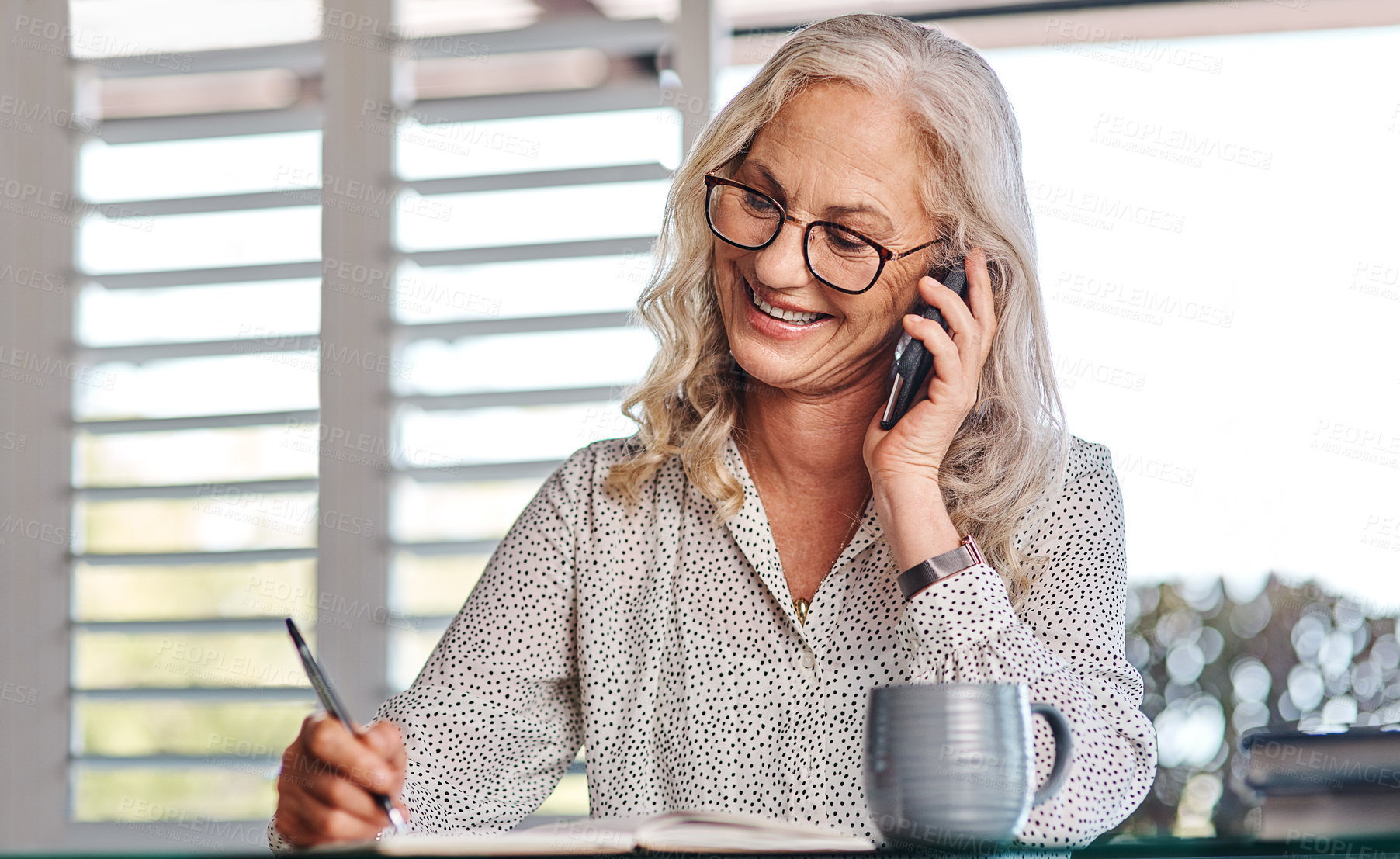 Buy stock photo Cropped shot of an attractive senior businesswoman taking a phonecall while working from home