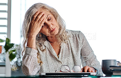 Buy stock photo Cropped shot of an attractive senior businesswoman suffering with a headache while working from home