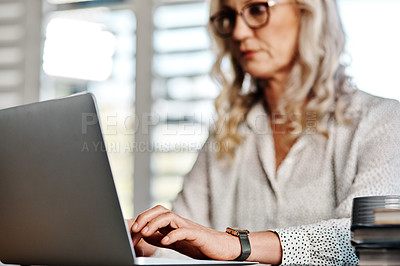 Buy stock photo Cropped shot of an unrecognizable senior businesswoman using a laptop while working from home