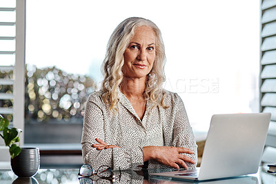 Buy stock photo Cropped portrait of an attractive senior businesswoman using a laptop while working from home