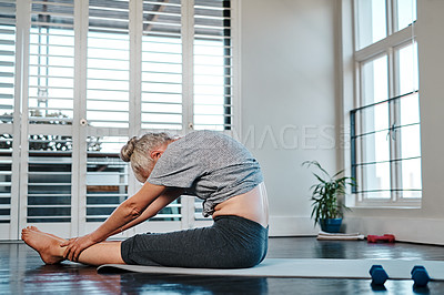 Buy stock photo Shot of a relaxed mature woman practicing yoga inside of a studio during the day