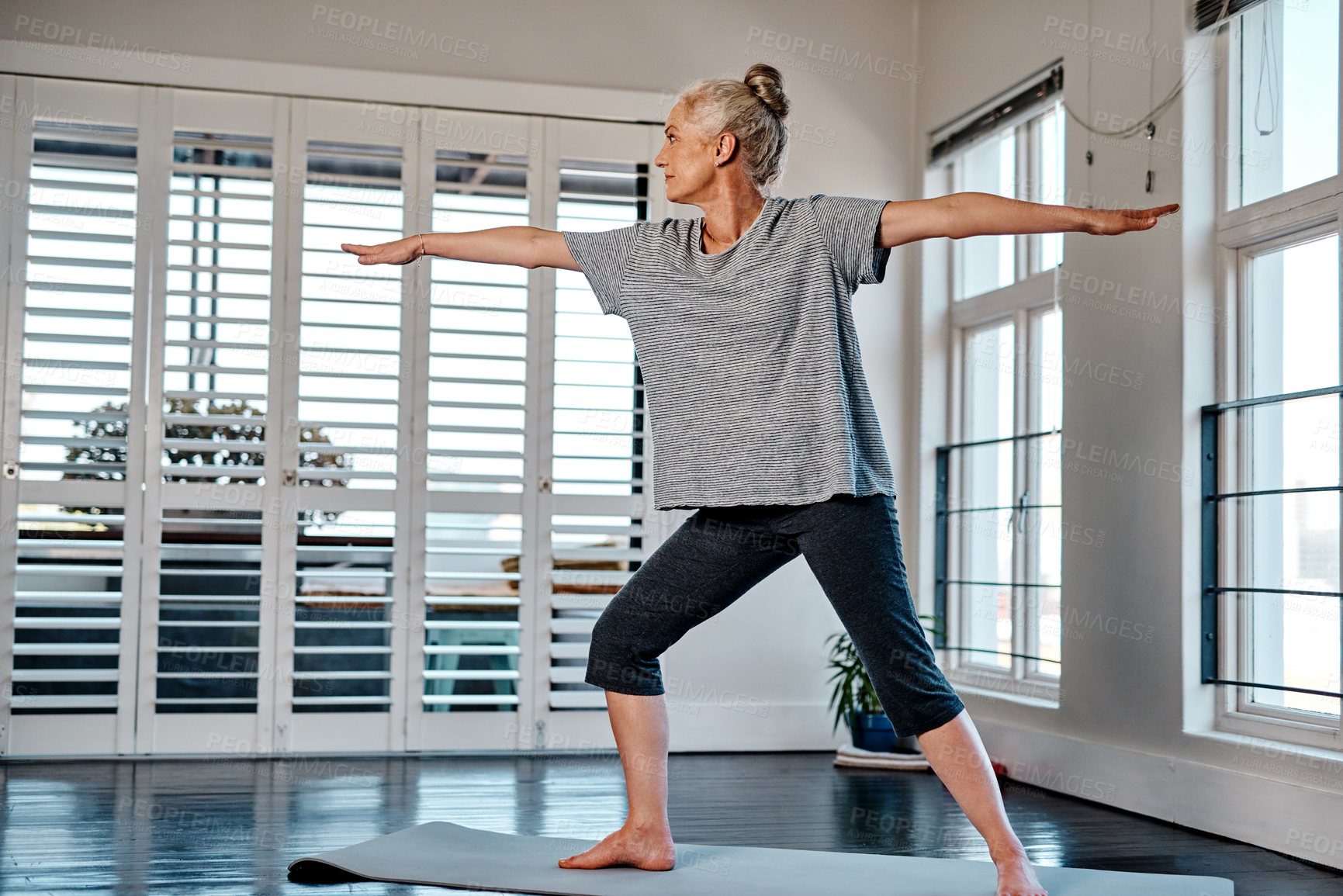 Buy stock photo Shot of a relaxed mature woman practicing yoga inside of a studio during the day