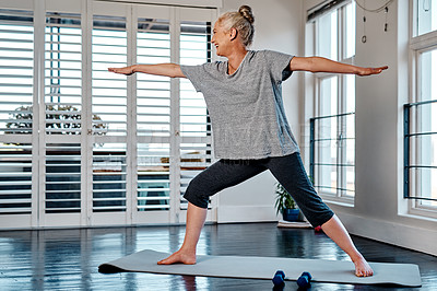 Buy stock photo Shot of a relaxed mature woman practicing yoga inside of a studio during the day