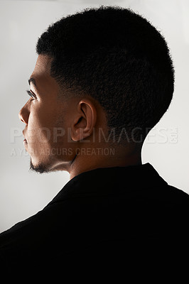 Buy stock photo Rearview shot of a handsome young man posing against a grey background inside of a studio