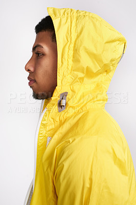 Buy stock photo Studio shot of a handsome young man wearing a bright yellow hoodie while standing against a grey background inside of a studio