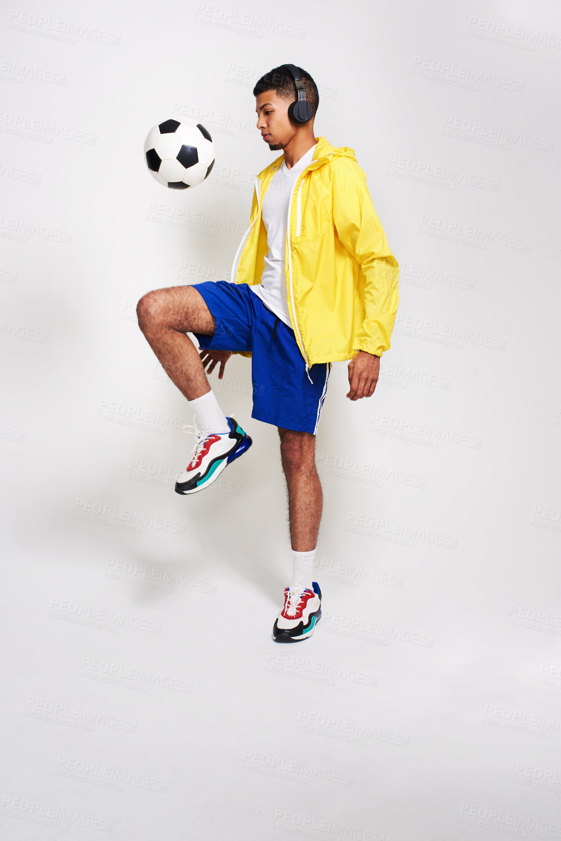 Buy stock photo Man, fashion or playing with soccer ball or headphones for music or sport game on a gray studio background. Young, male person or Italian model with football, headset or style for podcast or practice