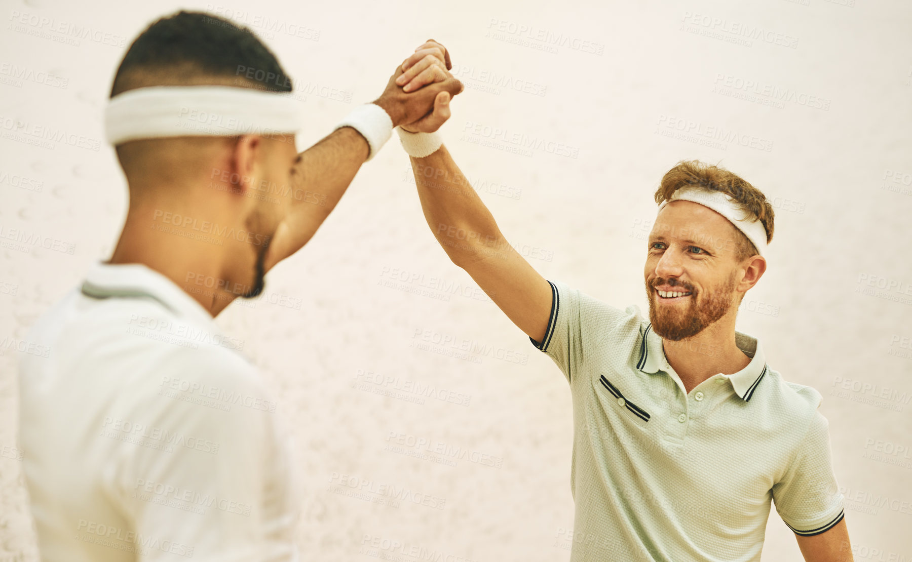 Buy stock photo Shot of two young men giving each other a high five before playing a game of squash