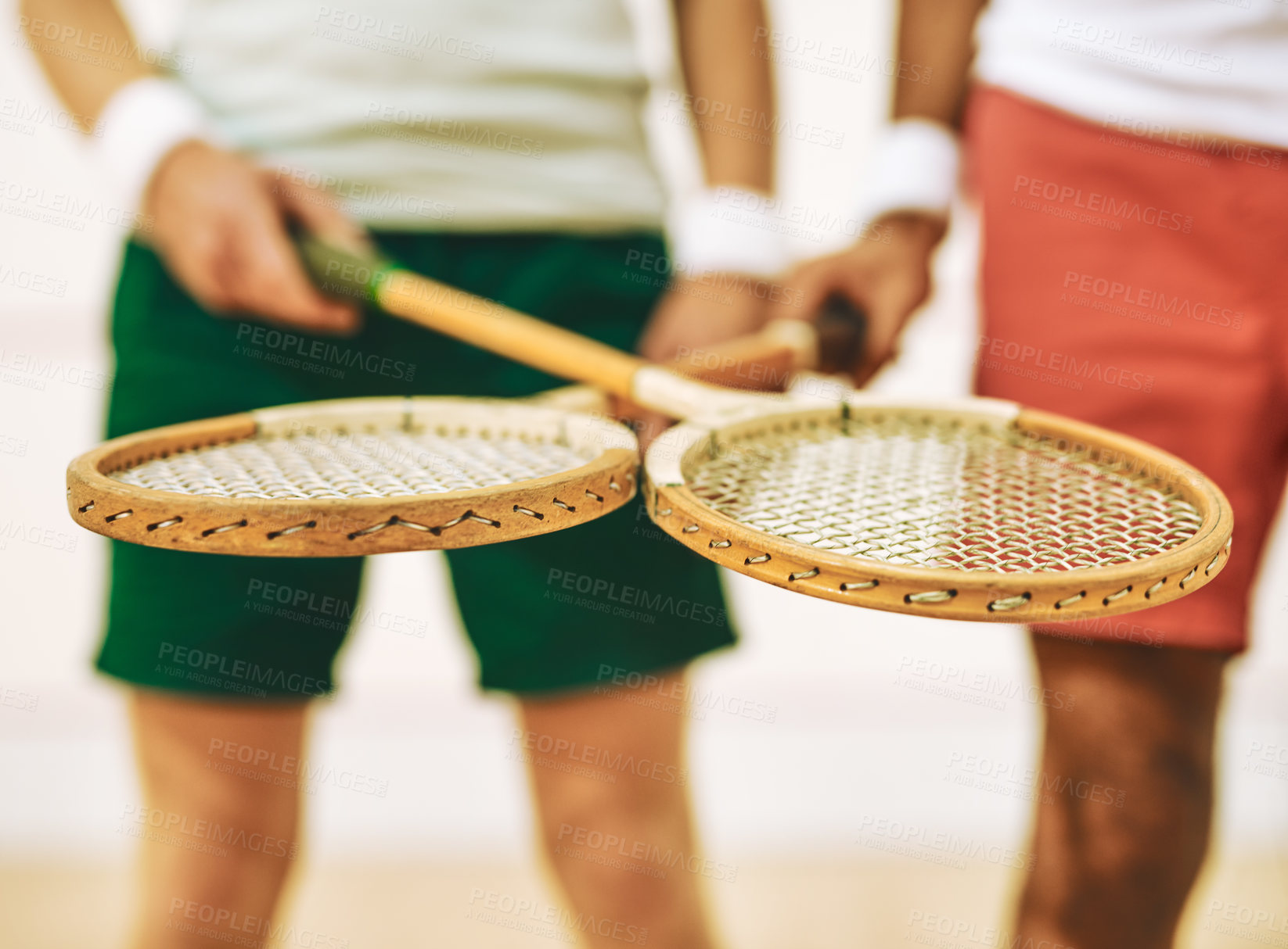 Buy stock photo Cropped shot of two men crossing their racquets at a squash court