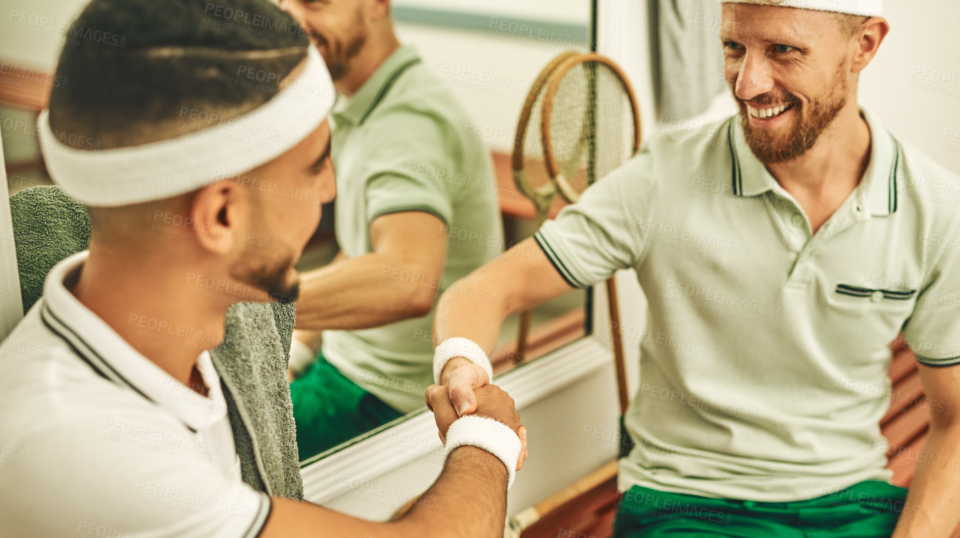 Buy stock photo Shot of two young men shaking hands in the locker room after a game of squash