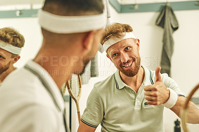 Buy stock photo Shot of a young man giving his friend a thumbs up in the locker room after a game of squash