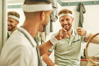 Buy stock photo Shot of two young men fist bumping in the locker room after a game of squash