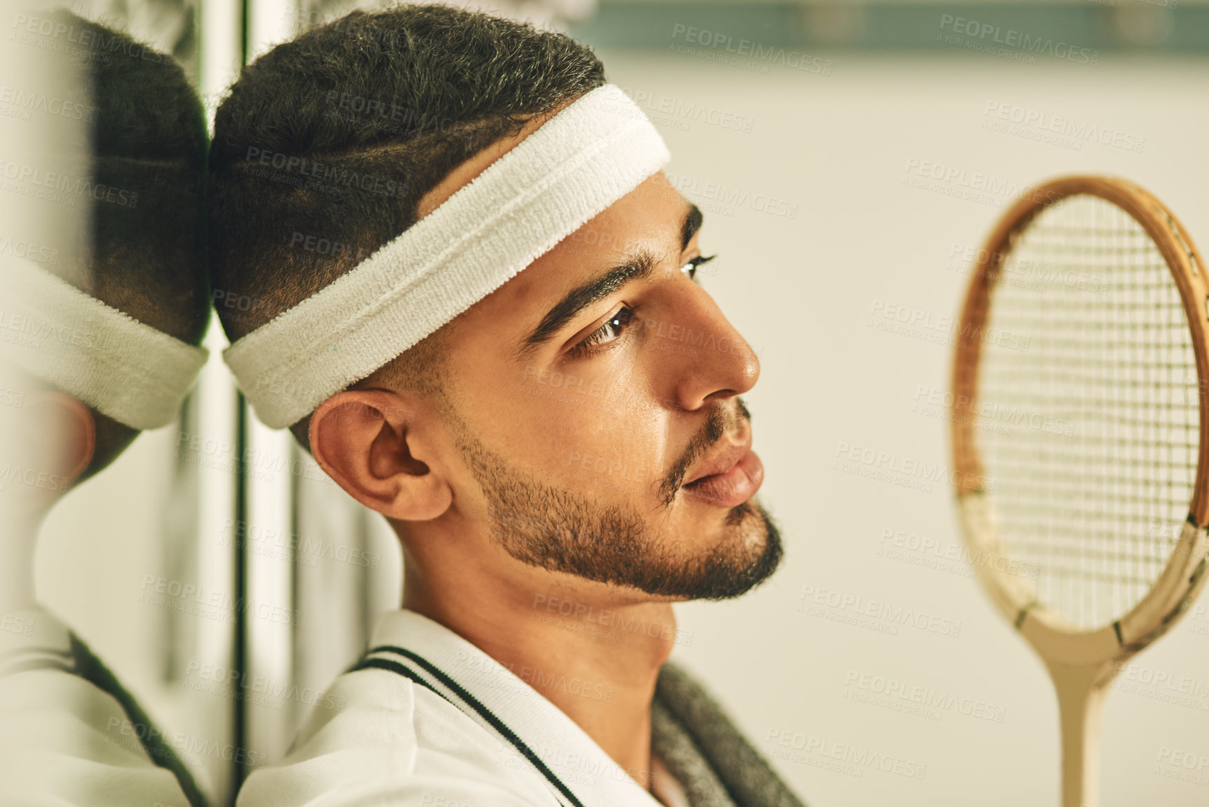 Buy stock photo Shot of a young man looking thoughtful in the locker room after a game of squash