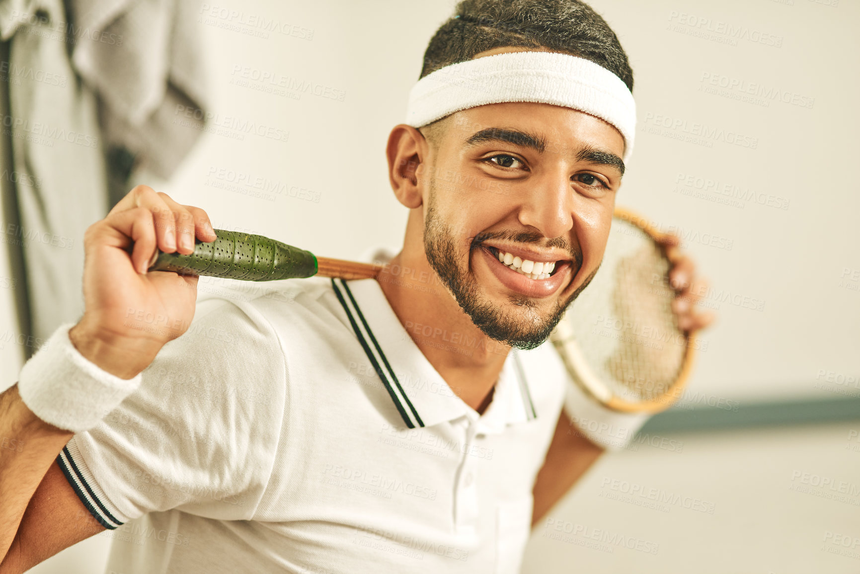 Buy stock photo Portrait of a happy young man holding his squash racket in the locker room
