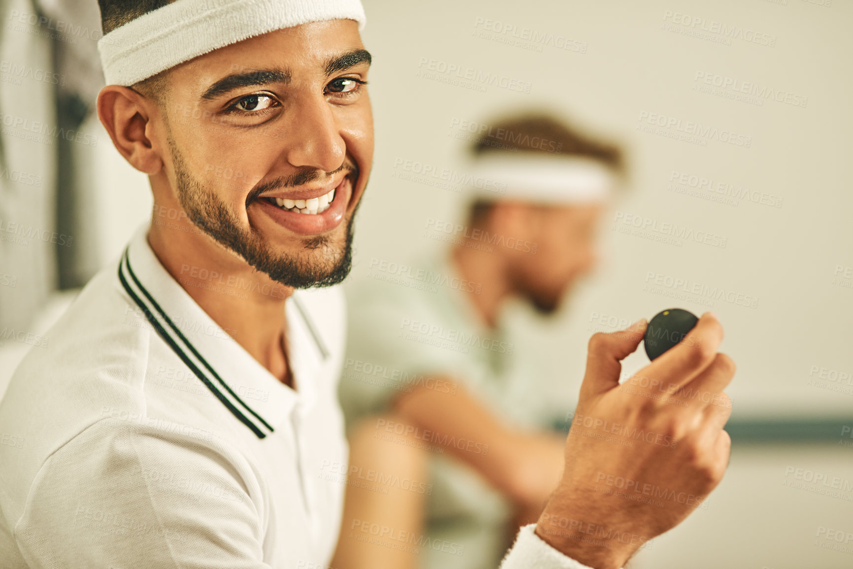 Buy stock photo Shot of a young man holding a squash ball at a sports venue