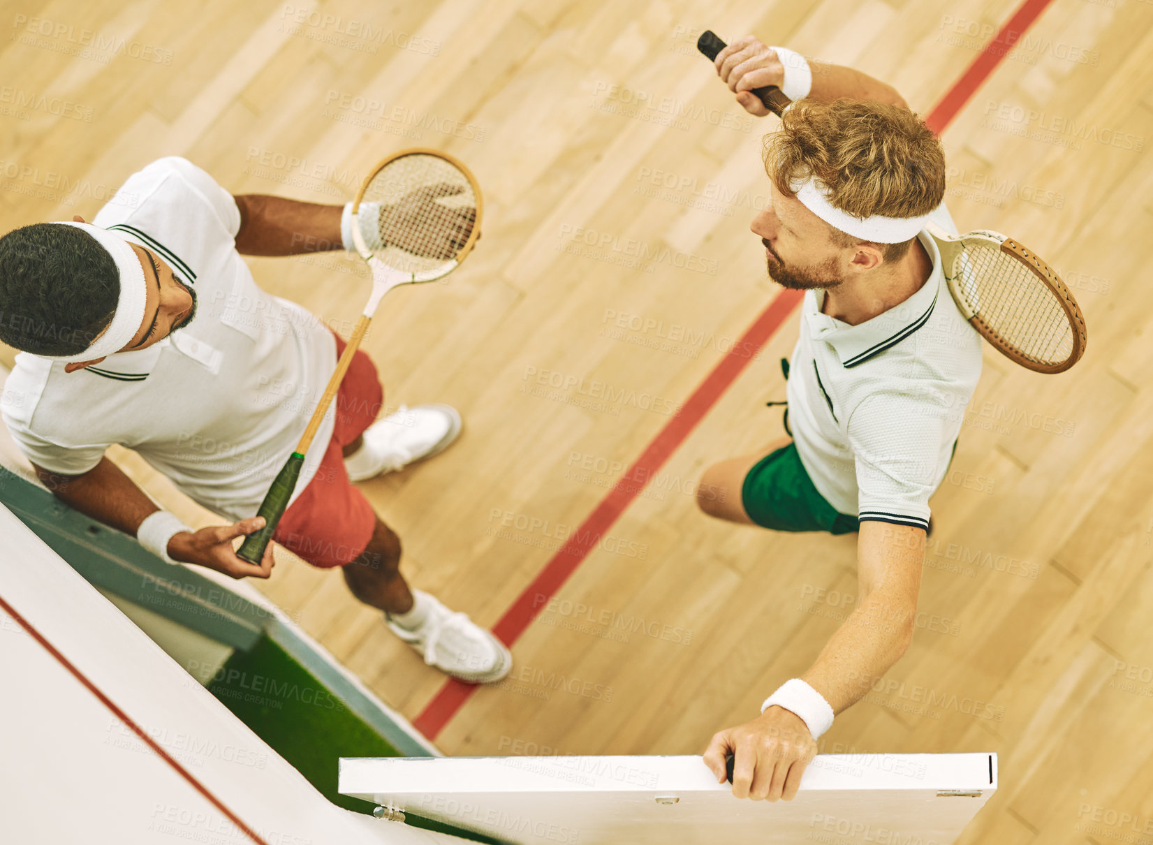 Buy stock photo High angle shot of two young men at a squash court