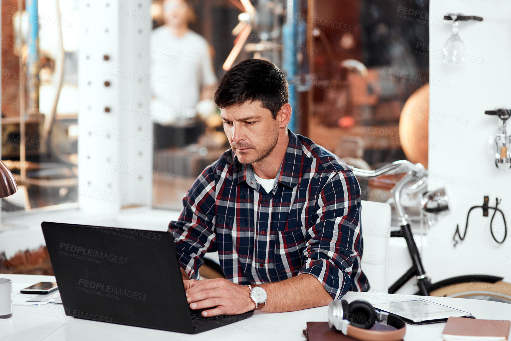Buy stock photo Cropped shot of a handsome young businessman working on a laptop in an office inside his workshop