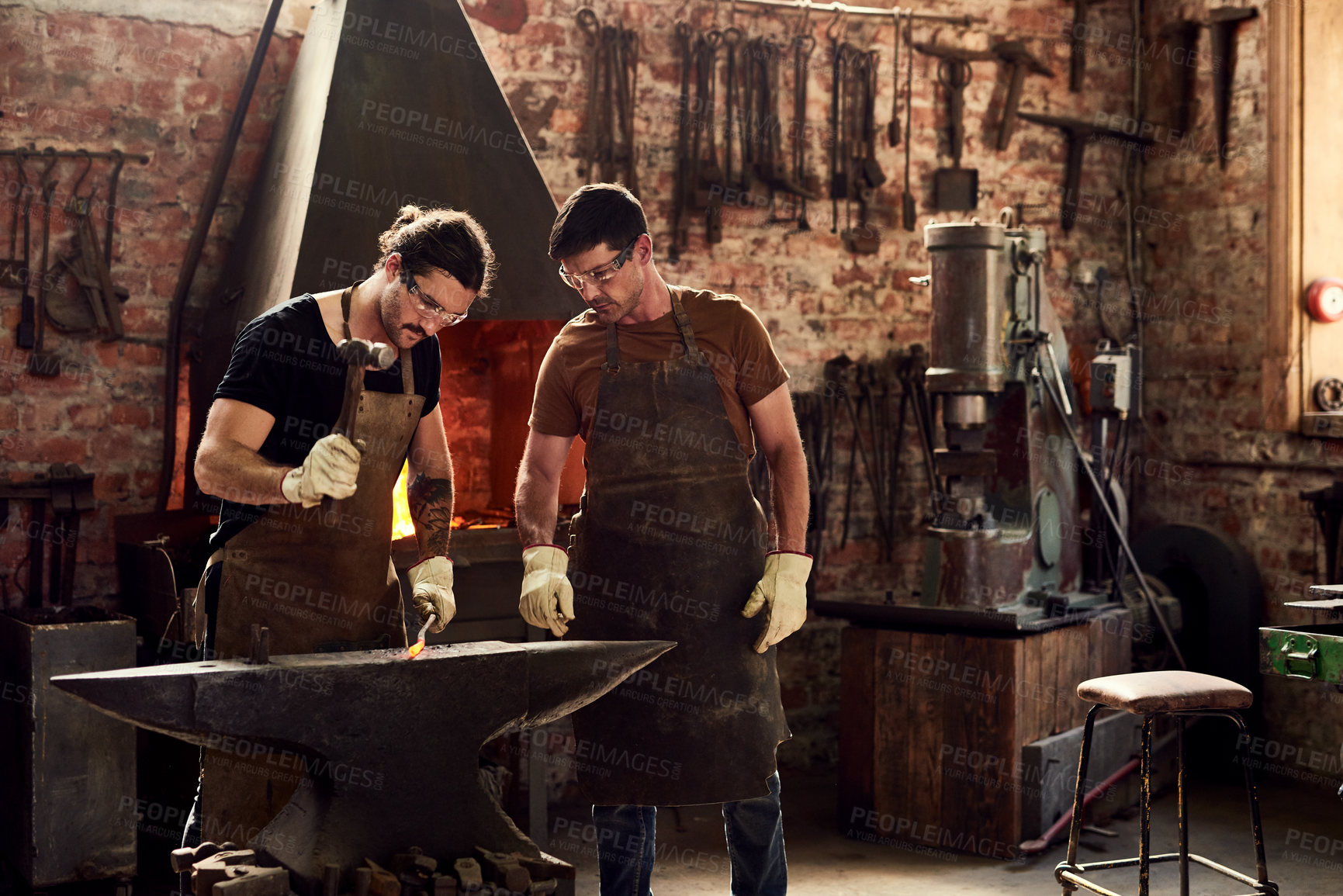 Buy stock photo Welding, craftsmen working and in a metal workshop together with protection gear. Collaboration or teamwork, manufacturing and ppe with welder men with hammer work on iron at their workplace