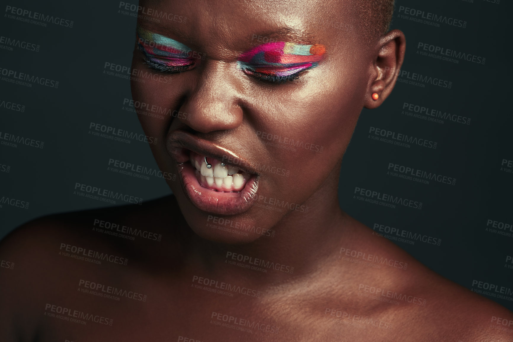 Buy stock photo Black woman, studio and paint with makeup for charm or angry face, color for beauty or cosmetics. Female person, open mouth and dark background for aesthetic wellness with eyes closed or frustrated