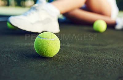 Buy stock photo Closeup shot of a tennis ball on a tennis court with an unrecognisable woman sitting in the background