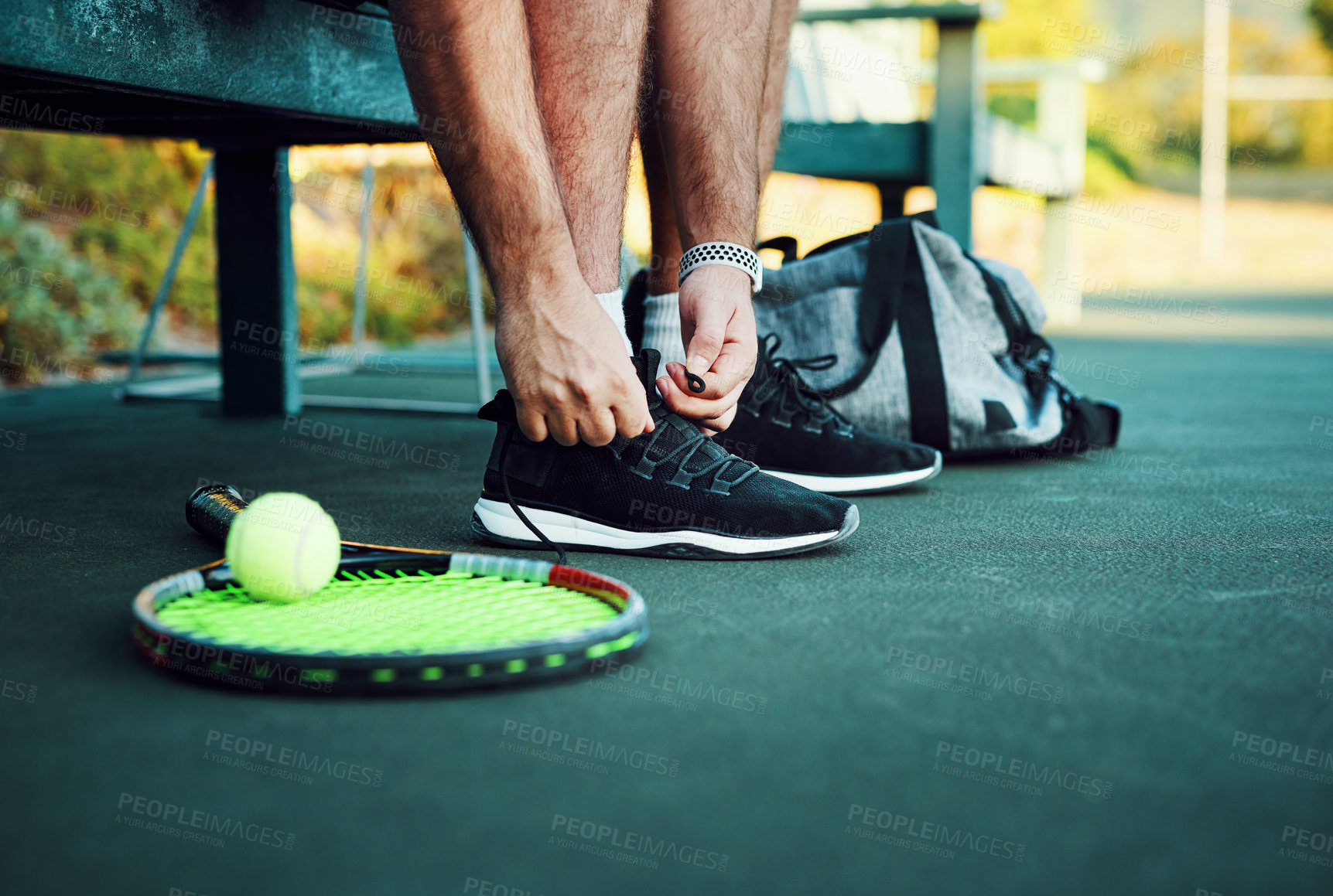 Buy stock photo Closeup shot of an unrecognisable man tying his laces on a tennis court