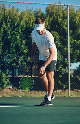 Buy stock photo Shot of a sporty young man playing tennis on a tennis court