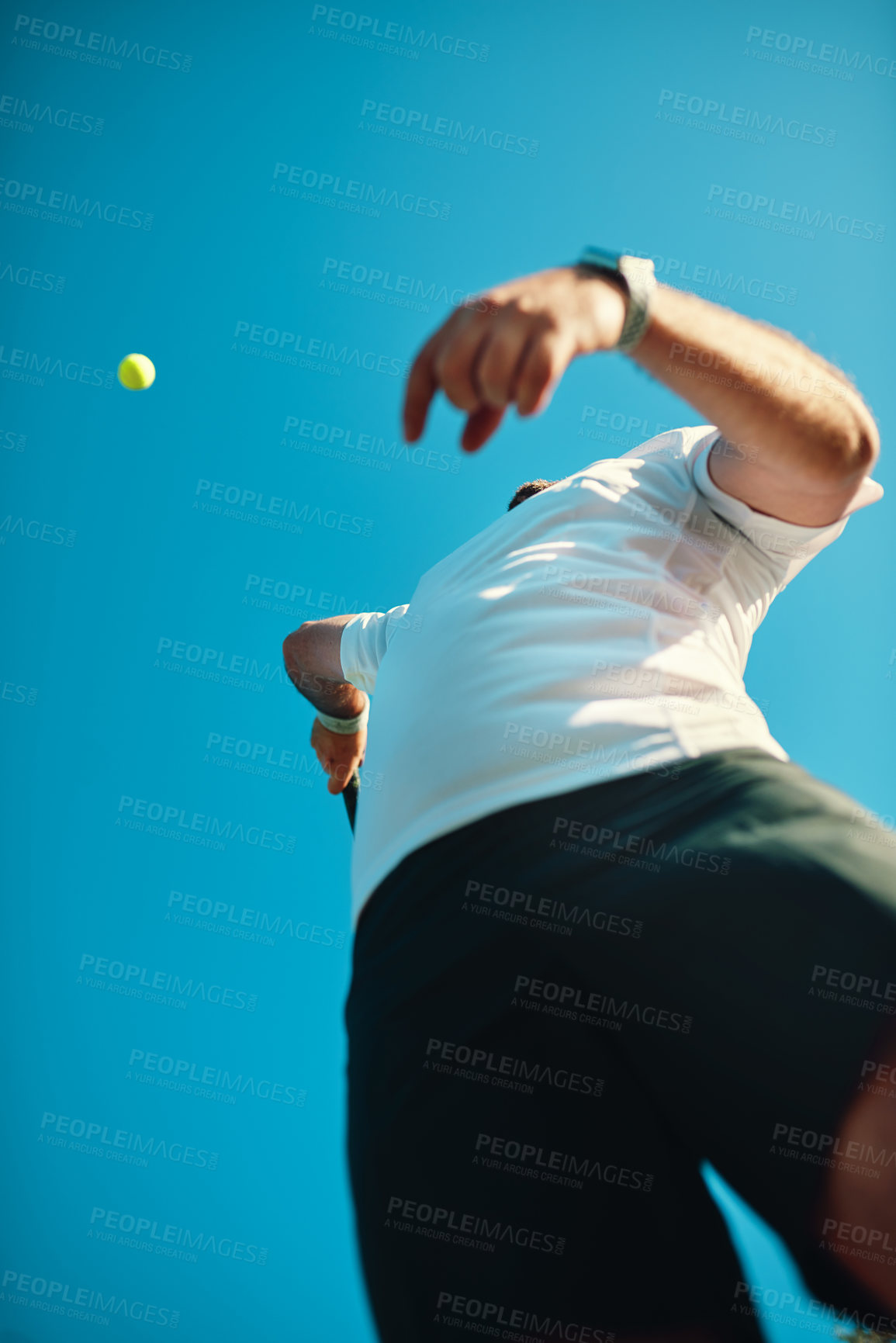 Buy stock photo Low angle shot of a sporty young man playing tennis