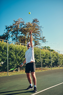 Buy stock photo Shot of a sporty young man playing tennis on a tennis court