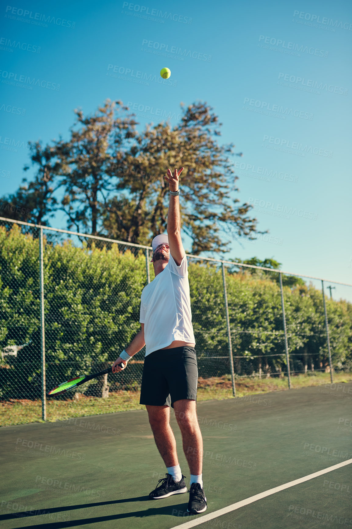 Buy stock photo Man, tennis and sport with ball in air for serve, game or match start on outdoor court. Young, male person or athlete with swing in training or practice for playing, competition or tournament