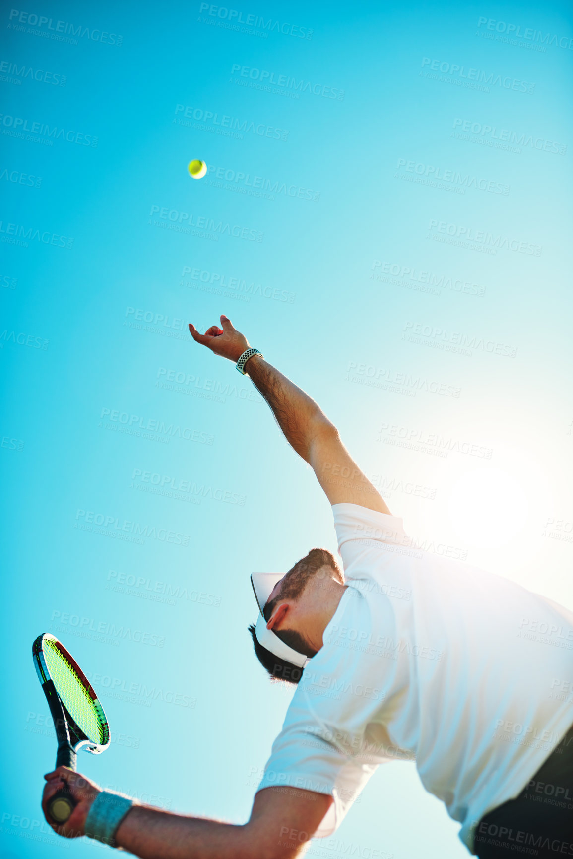 Buy stock photo Low angle shot of a sporty young man playing tennis