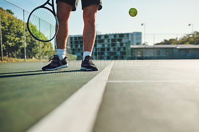 Buy stock photo Closeup shot of an unrecognisable man playing tennis on a tennis court