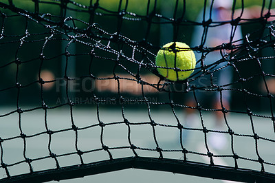 Buy stock photo Cropped shot of a tennis ball hitting a tennis net on the court during the day