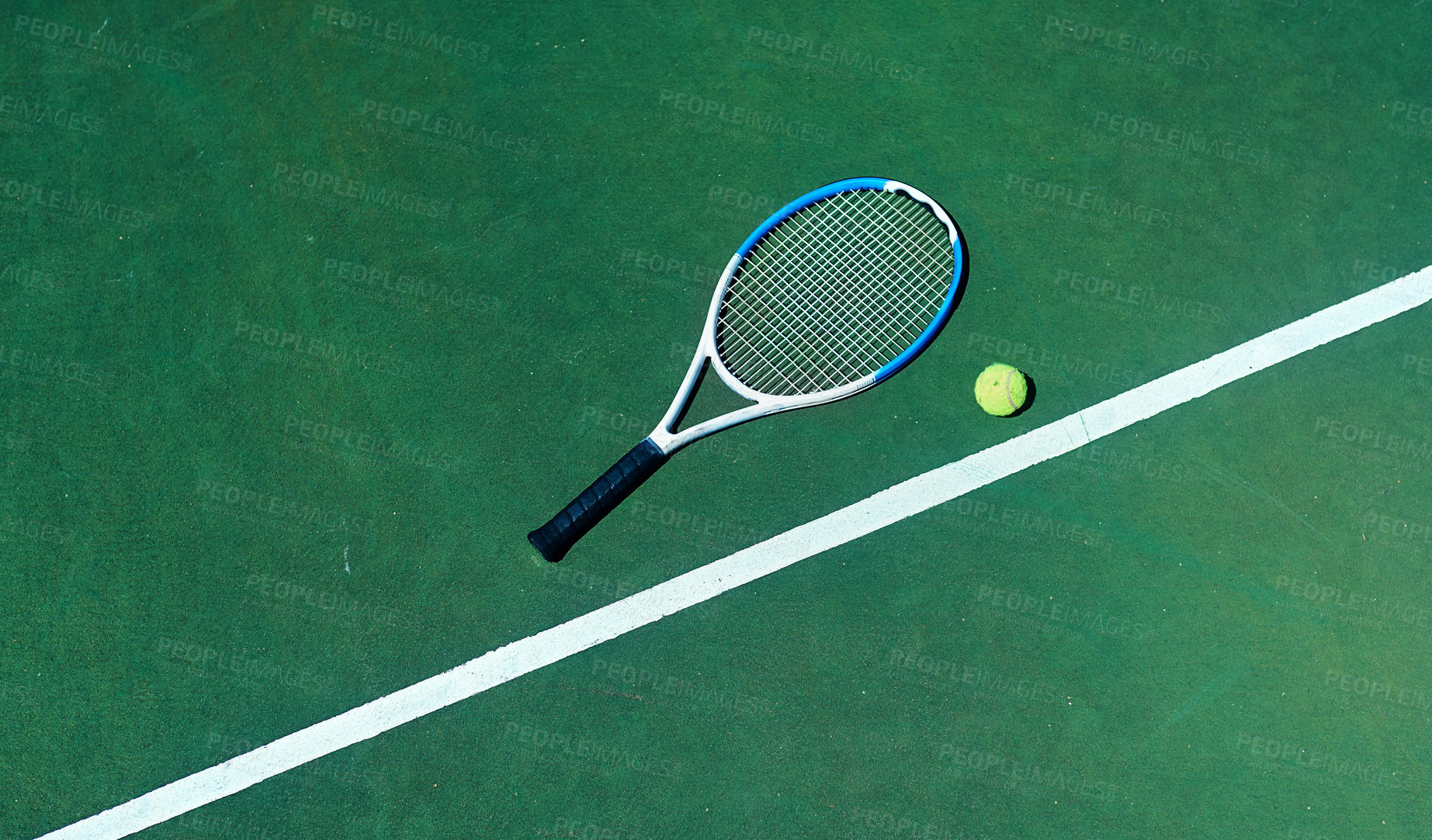 Buy stock photo Cropped shot of a tennis racket and ball on an empty court during the day