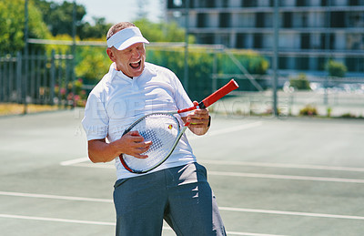 Buy stock photo Cropped shot of a handsome mature man feeling playful while playing tennis alone during the day