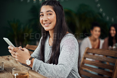 Buy stock photo Shot of a beautiful young woman using a smartphone at a cafe