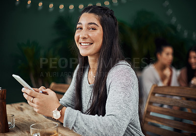 Buy stock photo Shot of a beautiful young woman using a smartphone at a cafe