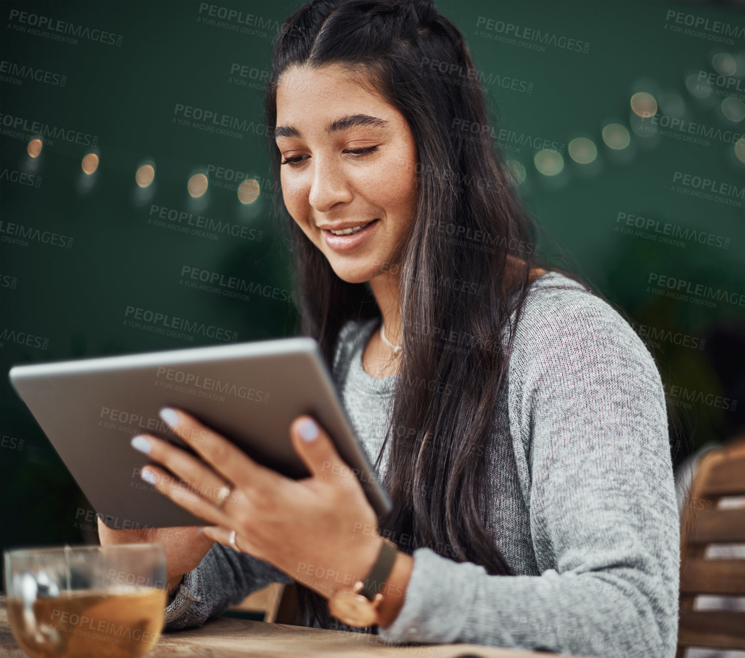 Buy stock photo Shot of a beautiful young woman using a digital tablet at a cafe