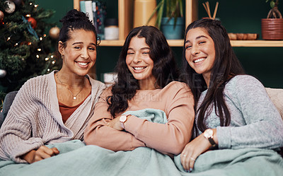 Buy stock photo Shot of young sisters relaxing on the sofa together during Christmas at home